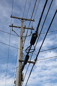 Low angle view of telephone pole against sky