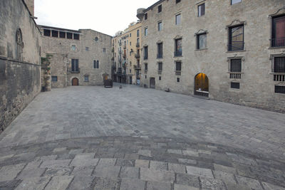 Empty alley amidst buildings in city