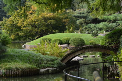 Arch bridge over lake against trees