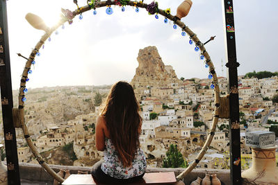 Rear view of woman looking at buildings in city