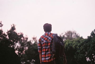 Rear view of man standing against sky during sunset