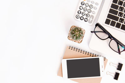 Directly above shot of technologies and objects against white background