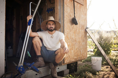 Portrait of confident male farmer sitting in cabin on field
