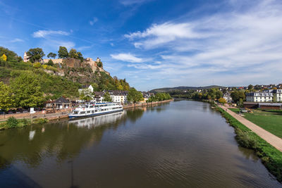 Scenic view of river by buildings against sky