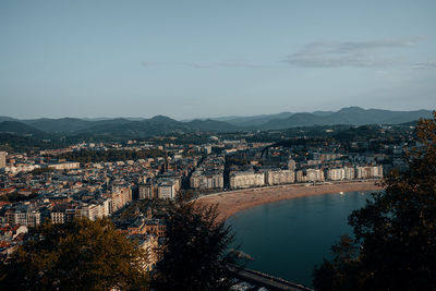 High angle view of townscape by river against sky