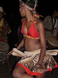 Close-up of woman with red hands at night