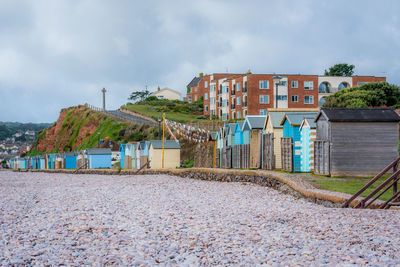 Houses on beach by buildings against sky