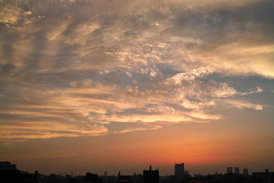 Silhouette cityscape against sky during sunset