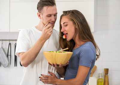 Young woman holding ice cream at home