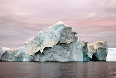 Scenic view of sea, iceberg and sky