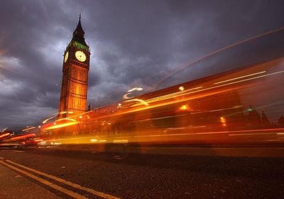 Illuminated clock tower against sky in city at night