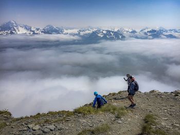 People on mountain against sky