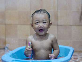 Portrait of shirtless baby boy in bathroom