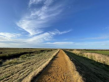 Dirt road along countryside landscape