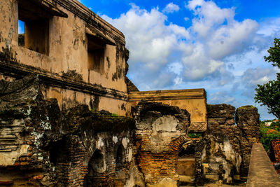 Low angle view of old building against cloudy sky