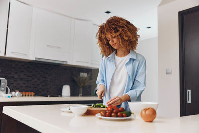 Portrait of woman using mobile phone at home