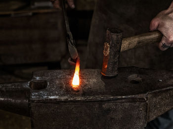 Midsection of man working on metal