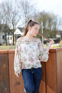 Teenage girl standing against railing