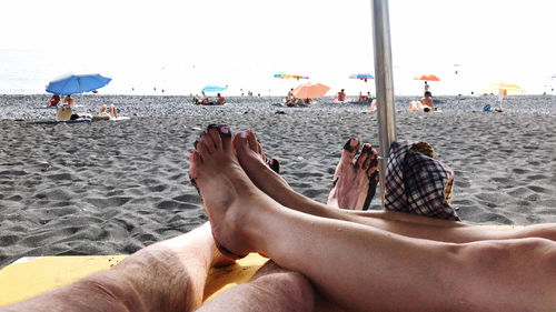 Low section of woman relaxing on beach