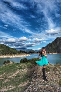 Woman standing on mountain against sky