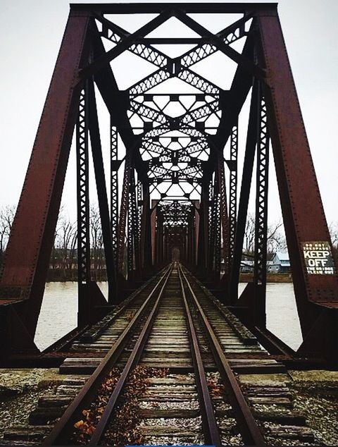 connection, built structure, architecture, bridge - man made structure, transportation, diminishing perspective, the way forward, engineering, vanishing point, metal, railroad track, sky, long, railway bridge, bridge, rail transportation, metallic, no people, outdoors, low angle view
