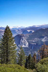 Scenic view of snowcapped mountains against clear blue sky