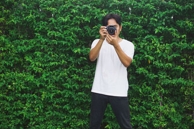 Young man photographing on camera