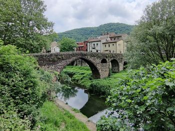 Arch bridge over river against sky