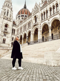  view of woman standing in front of historic building