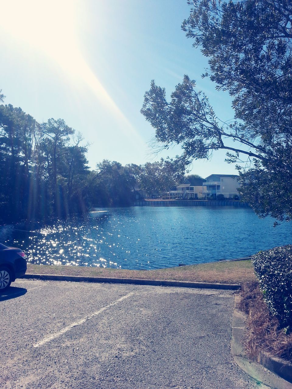 water, tree, sunlight, sky, sunbeam, sun, river, nature, fountain, lens flare, sunny, lake, tranquility, reflection, day, blue, beauty in nature, built structure, outdoors, park - man made space