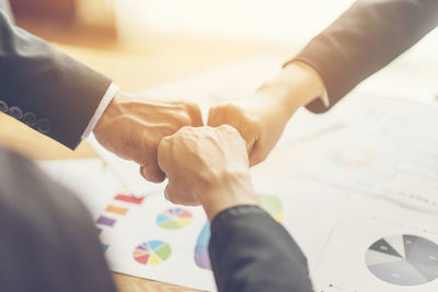 Close-up of business people bumping fist at office