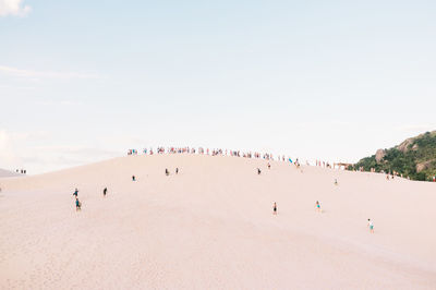 People at beach against clear sky