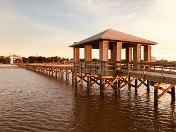 Wooden pier over sea against sky during sunset