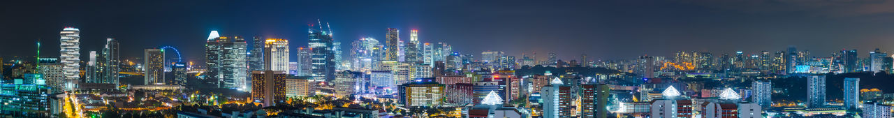 Panoramic shot of illuminated buildings against sky at night