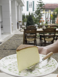 Cropped hand of woman having breakfast on table