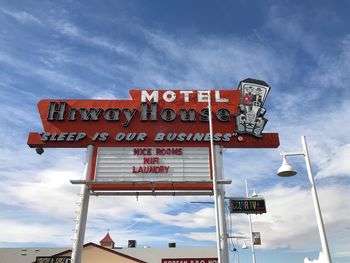 Low angle view of road sign against sky