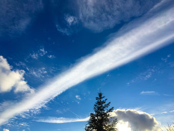 Low angle view of sunlight streaming through clouds