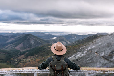 Person standing on mountain against sky