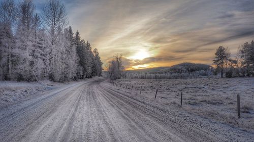 Snow covered field at sunset