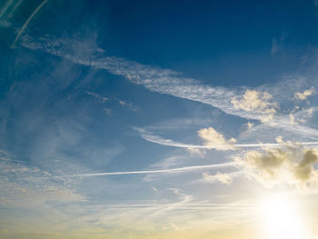 High altitude clouds against a blue sky and bright sunshine over rural suffolk, uk