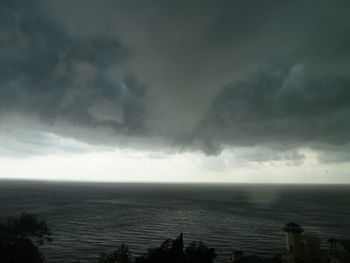 Scenic view of sea against storm clouds
