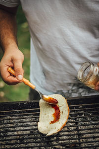 Midsection of man working on barbecue grill