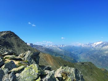 Scenic view of mountains against blue sky