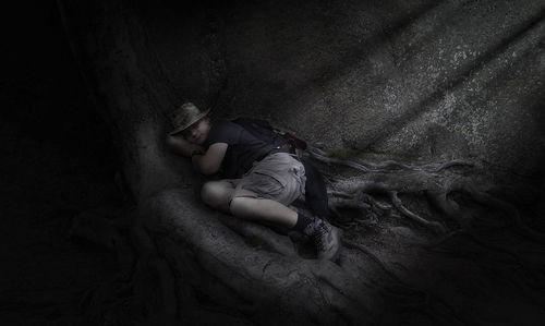 High angle view of man sleeping on tree trunk