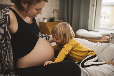 Girl talking to pregnant mother's belly