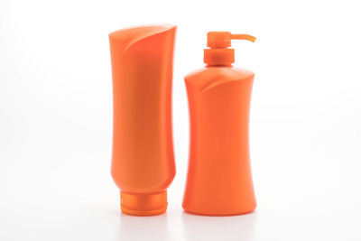 Close-up of orange bottle against white background