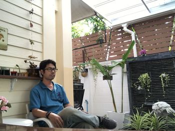 Young man sitting on potted plant