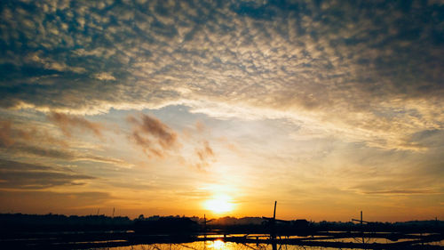 Scenic view of dramatic sky over city during sunset