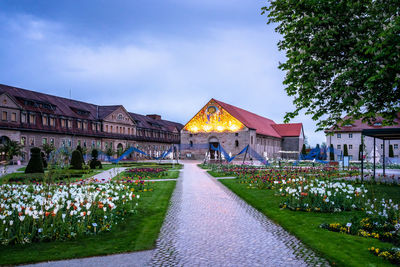 Footpath amidst houses and buildings against sky