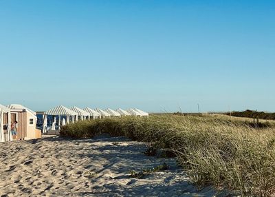 Scenic view of beach against clear blue sky